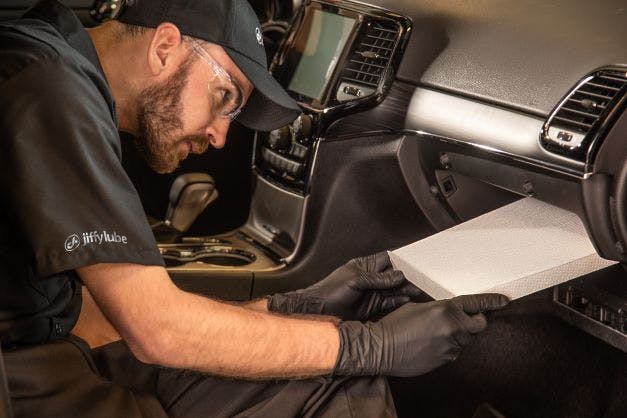 JLI Service member replacing a clogged cabin filter with a clean one to help cool a hot car